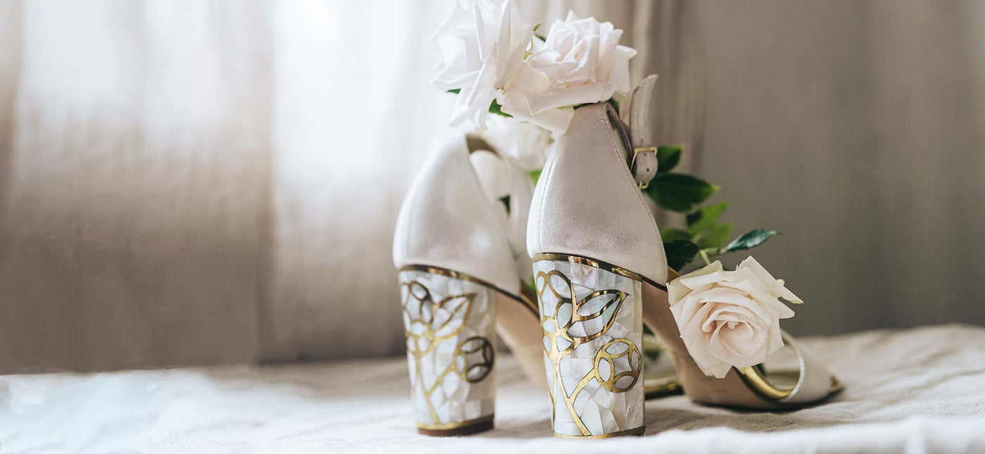 A pair of Freya Rose Couture shoes covered with delicate white roses.