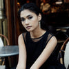 A model wearing Delicate Gold Pearl Drop Earrings by Freya Rose London