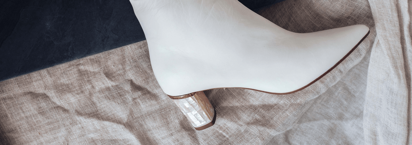 A Freya Rose Low Heel Bridal Boot laid against white fabric.