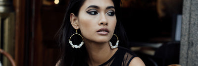 A side profile of a woman wearing pearl earrings from Freya Rose's Designer Jewellery Collection.