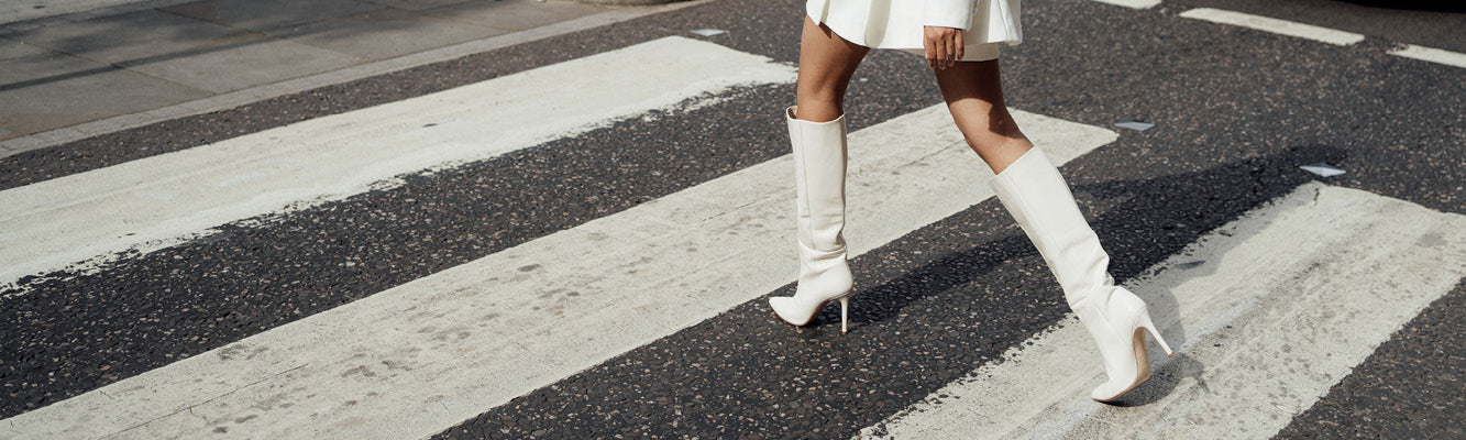 Women walking in striking knee high white leather high heel designer wedding boots