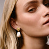 Lion pearl drop earrings in 18ct gold vermeil featuring textured lion motif and baroque pearl drops.