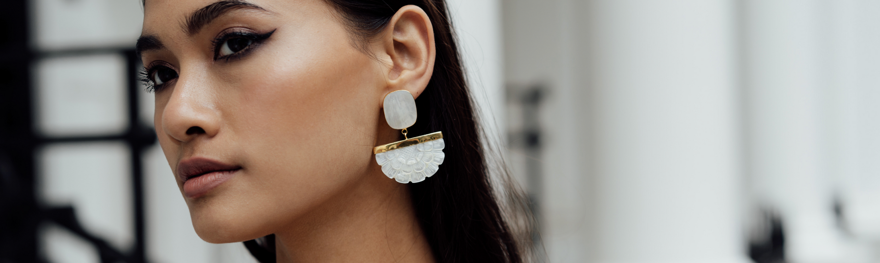 women wearing statement hand carved mother of pearl and 22ct gold vermeil floral earrings 