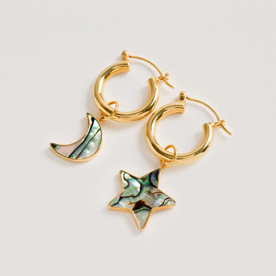 Product image of Gold Mini Hoop Earrings with detachable star and moon pendants made of paua shell by Freya Rose London 