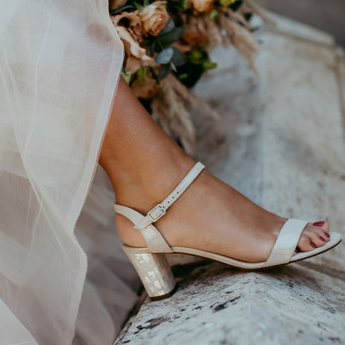 Martina Midi Champagne worn by a model - A shimmer suede mid-heel bridal shoe with Pearl Heels